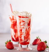 Topping Crème Sweet Strawberry in einem Glas mit einem Erdbeershake