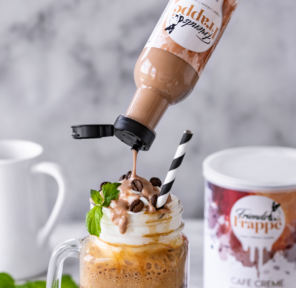 Topping Creme Choc Hazelnut von Friends Frappé wird zur Dekoration über einen Eiskaffee gegeben