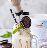 Topping Creme Crunchy Black Cokkie von Friends Frappé wird über einen Yogurt Milchshake getreufelt